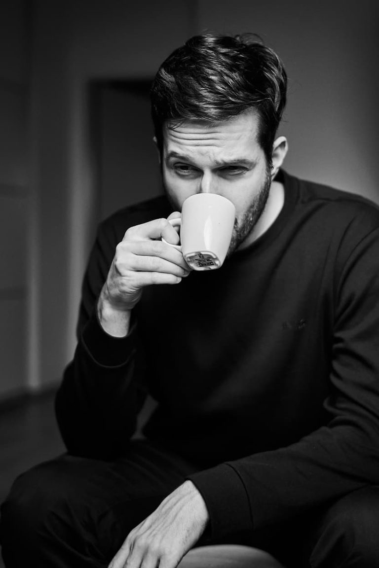 Schwarz und weißes Foto eines Mannes der Kaffee trinkt. Sprecher Lukas Wurm